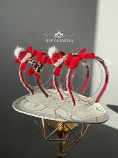 three red and white headbands on top of a metal stand in front of a wall