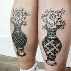 two black and white vases with flowers in them on both legs, one is showing