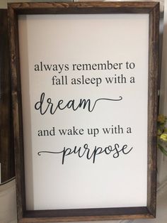 a framed sign that says, always remember to fall asleep with a dream and wake up with a purpose