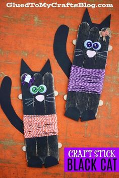 two black cats made out of paper and yarn