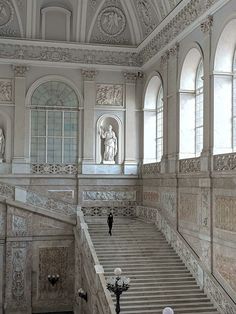 an old building with stairs and statues on the walls