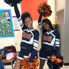 two cheerleaders are posing for the camera