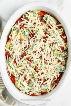 a white bowl filled with broccoli and cheese on top of a marble counter