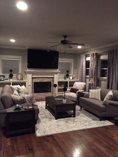 a living room filled with furniture and a flat screen tv mounted to the wall over a fireplace