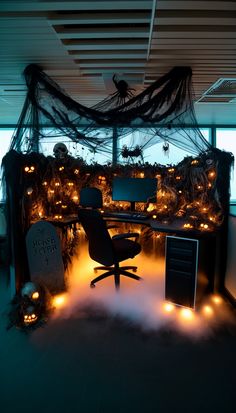 an office decorated for halloween with lots of lights on the desk and ghost net hanging from the ceiling