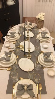 the table is set with silver and white dishes