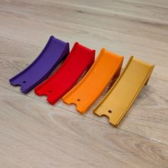 four different colored plastic handles on a wooden floor