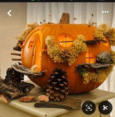 a pumpkin decorated with moss and pine cones