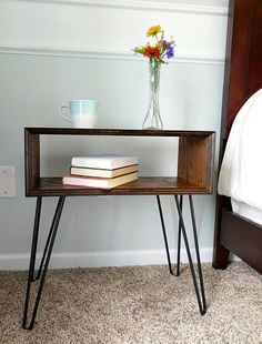 a table with some books on it and a vase full of flowers next to it