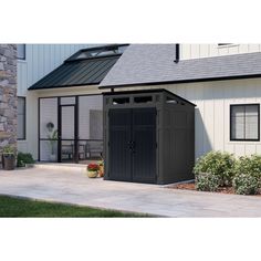 an outdoor storage shed in front of a house