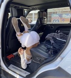 a person sitting in the back seat of a car with their feet propped up on luggage