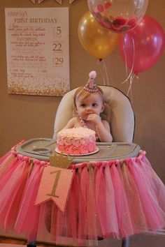 a baby sitting in a high chair with a birthday cake