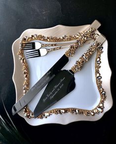 a white plate topped with two black and gold utensils