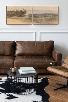 a living room with two brown leather couches and a coffee table in front of it