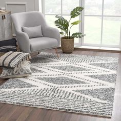 a living room with a chair, rug and potted plant