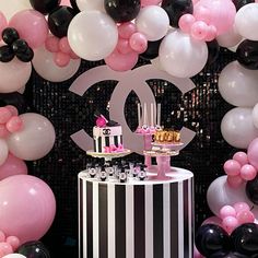 a chanel themed birthday party with black, white and pink balloons in the background