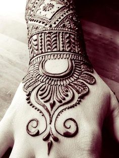 the hand is decorated with henna on it and has an intricate design in black and white