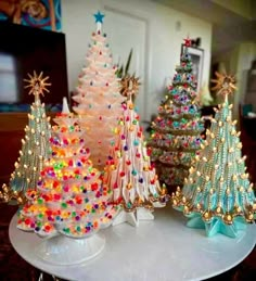 three small christmas trees sitting on top of a white table next to each other in front of a mirror