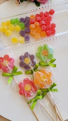 candy lollipops in cello bags on a tray with flowers and roses next to them