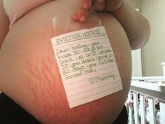 a pregnant woman holding a piece of paper with writing on it