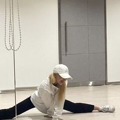 a woman laying on the floor in front of a pole with chains attached to it