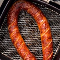 two sausages are cooking on the grill