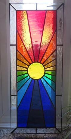 a stained glass window with the sun shining through it