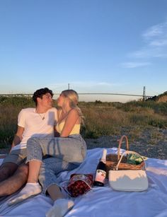 a man and woman are sitting on a blanket