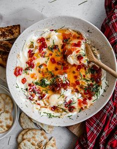 a white bowl filled with food next to crackers