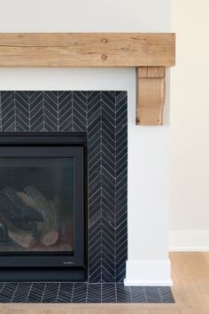 a fire place with a black and white tile fireplace in the center, surrounded by wood planks