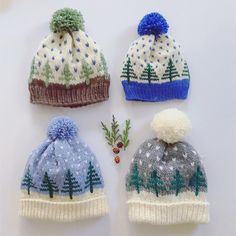 three knitted hats with trees on them, one is blue and the other is green