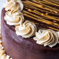 a chocolate cake with white frosting and nuts on top