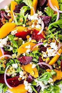 a salad with beets, oranges and feta cheese on top is shown