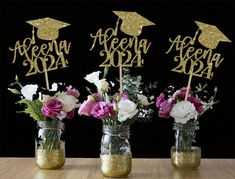 three mason jars filled with flowers and gold glitter graduation decorations