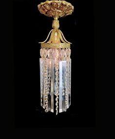 an antique chandelier with crystal beads hanging from it's centerpiece on a black background