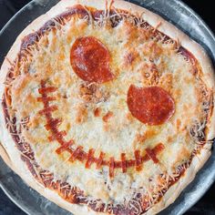 a pizza with pepperoni and cheese in the shape of a smiley face on it