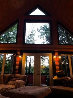 a living room filled with furniture and a large open window on the wall above it