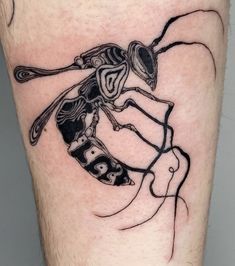 a man's leg with a black and white insect tattoo on it