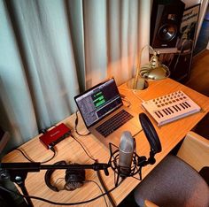 a laptop computer sitting on top of a desk next to a microphone and headphones