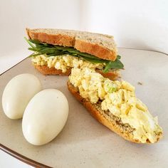 an egg sandwich and two pieces of bread on a plate