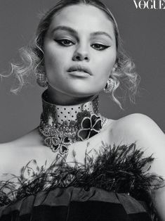 a woman in black and white is posing for the cover of a magazine, with feathers on