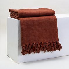 a brown towel is sitting on top of a white box and it's folded up