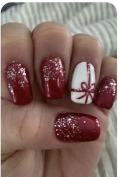 a person with red and white nail polish on their nails