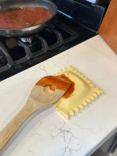 a wooden spatula with some food on top of it next to a stovetop