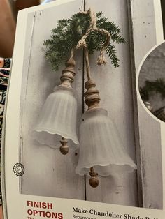 an open book with two bells hanging from it's side