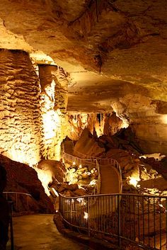 the inside of a cave with stairs leading up to it and lights shining on the walls