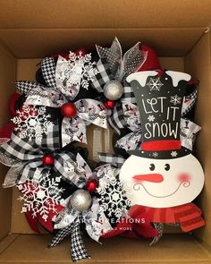 a christmas wreath in a box with snowman decorations on it and the words let it snow