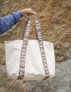 Large Everyday Tote er det perfekte funksjonelle statement-tilbehøret du vil ha med deg overalt. Denne overdimensjonerte vesken er designet for å passe alt fra favoritt-hettegenseren din til Bibelen din, og er samtalestarteren du har ventet på.

 Egenskaper




 førsteklasses lerretsmateriale


 1 innerlomme + hovedrom


 2 utvendige lommer

 EF-logotrykk på håndtaket

 20" x 14" x 5" Everyday Canvas Bag With Letter Print, Elevated Faith, Faith Sign, Christian Tote Bags, Unique Meaning, Oversized Tote, Everyday Tote, Conversation Starters, Canvas Material