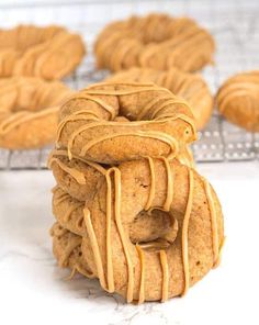 a stack of cookies with peanut butter drizzled over them on a cooling rack