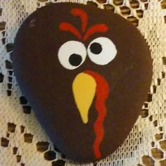 a painted rock with a turkey face on it